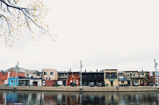 Small businesses and restaurants are visible from the riverwalk.